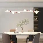 Подвесной рядный светильник с чередующимися белыми шарообразными плафонами и декоративными шариками красного цвета REIK LONG WHITE от ImperiumLoft Подвесной рядный светильник с чередующимися белыми шарообразными плафонами и декоративными шариками красного цвета REIK LONG WHITE от ImperiumLoft